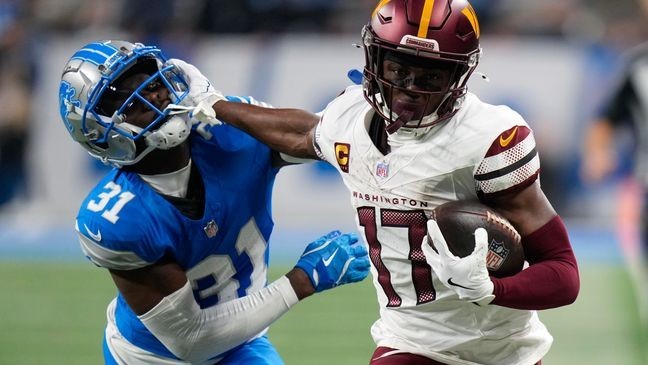 Washington Commanders wide receiver Terry McLaurin (17) stiff arms Detroit Lions safety Kerby Joseph (31) on a 58-yard touchdown reception during the first half of an NFL football divisional playoff game, Saturday, Jan. 18, 2025, in Detroit. (AP Photo/Seth Wenig)