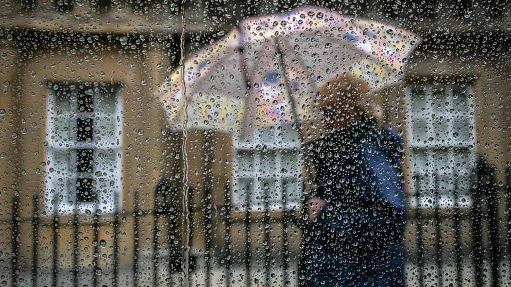 FILE - A woman passes a window covered in raindrops on October 6, 2014, in Bath, England. (Photo by Matt Cardy/Getty Images)