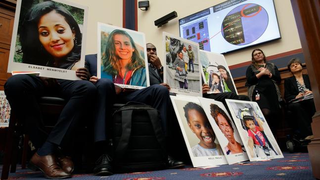 People holding photos of those lost in Ethiopian Airlines Flight 302 and Lion Air Flight 610 listen during a House Transportation and Infrastructure Committee hearing with Boeing executives, Wednesday, Oct. 30, 2019, on Capitol Hill in Washington. (AP Photo/Jacquelyn Martin)